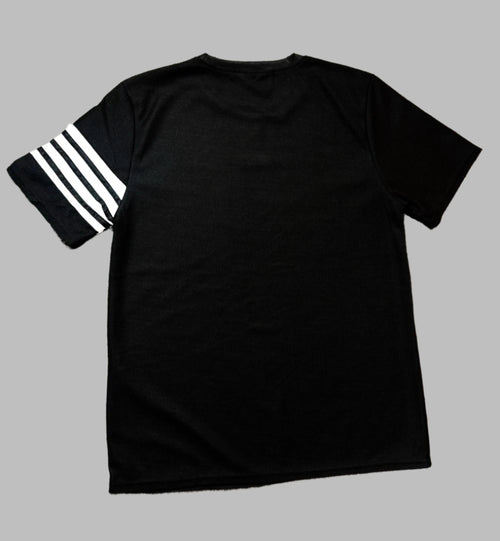 Black t-shirt with white stripes on sleeves on a light gray surface